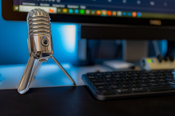 Retro Chrome Microphone on a Home Office Desk with Keyboard and Screen in shot but out of focus