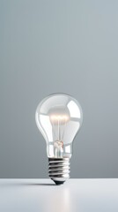 Silver backdrop with illuminated lightbulb on a white platform symbolizing ideas and creativity business concept creative thinking innovation new idea silver 