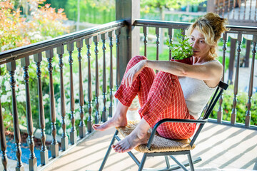 young mature woman relaxing at home on the porch.