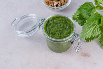 Stinging nettle pesto sauce in jar on a gray background. Appetizer, condiment or topping. Healthy...