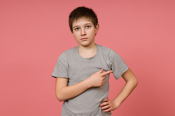 A little boy indicates the direction of movement with his finger against the background of a pink...