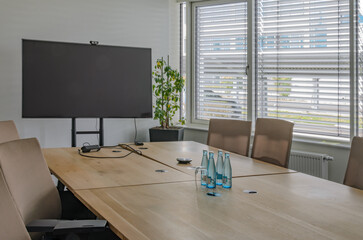 Conference room prepared meeting, water bottles, blinds, window, table, monitor