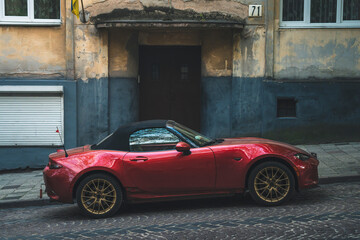 a red sports car is parked on the street
