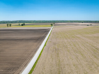 dusty road across farmland in a wide valley of the Missouri River near Wilton, MO, springtime aerial view