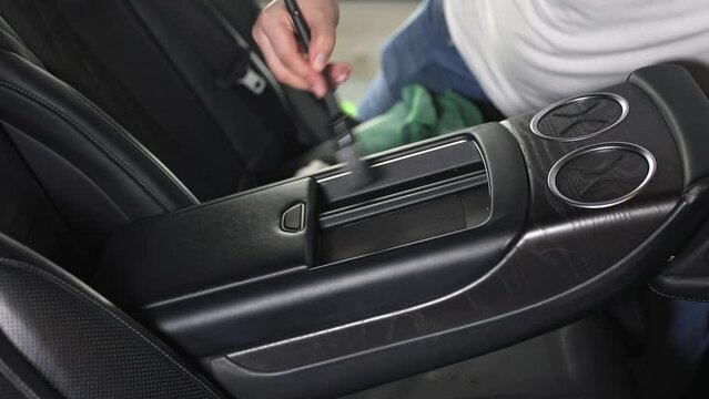Cleaning the car interior with a brush, a car detailing worker cleaning the car interior with a brush and foam, the concept of a car detailing