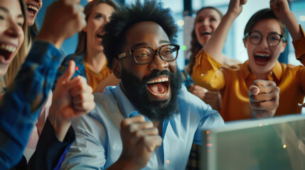 Obraz premium An emotional portrait of a group of office workers who are happy about completing a deal. People look at the computer screen, rejoice and have a great time