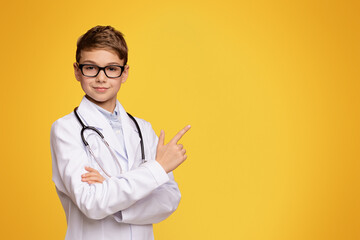 Important information. Serious teenager in doctor uniform pointing aside at empty space, orange...