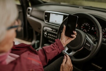 Senior woman driving, using GPS on smartphone