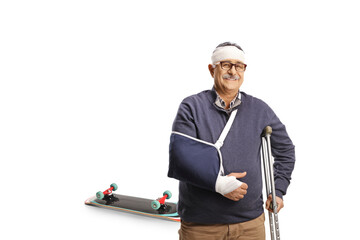 Mature man with a broken arm and bandage on head leaning on a crutch injured from a skateboard ride
