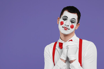 Funny mime artist posing on purple background. Space for text