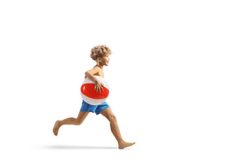 Boy running and holding a beach ball