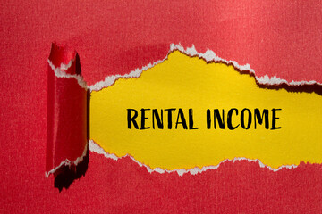 Rental income words written on ripped red paper with yellow background. Conceptual rental income...