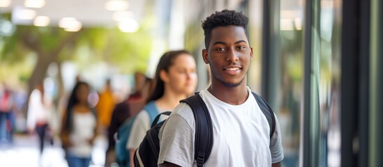 Handsome smart male student, studying in University with diverse multiethnic classmates. Afro-american smiling college or university student.