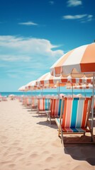 Fototapeta premium A row of beach chairs and umbrellas are set up on a sandy beach. The umbrellas are colorful and provide shade for the chairs.