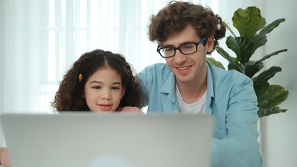 Father explain generate AI while american girl looking at screen. Attractive caucasian dad teaching...