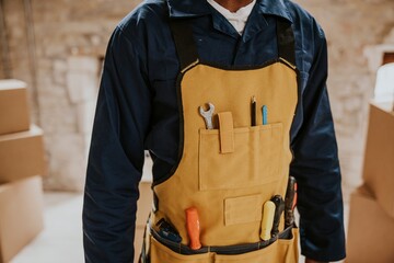 Construction worker wearing handyman apron with tools