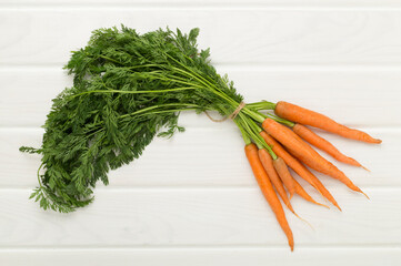 Bunch of fresh carrots on wooden background, top view