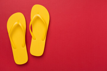 Bright yellow flip-flops on color background, top view. Summer concept