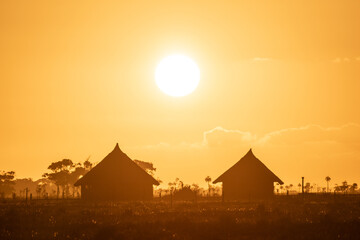 Sunset in the countryside with silhouette of wooden huts