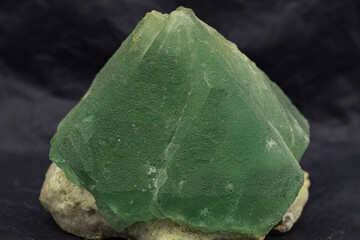 Robust and radiant green fluorite crystal, showcased on a contrasting dark background, highlighting...
