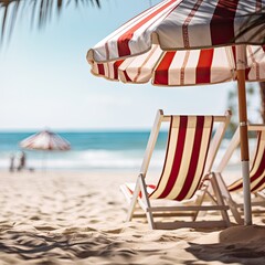 Deckchair under a striped umbrella, blurred background, copy space