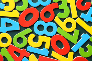 Colorful numbers on green background, top view