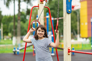 portrait of a happy smiling girl 11 years old playing on a children's playground. looking at the camera close-up.