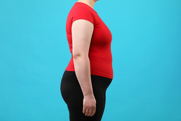 Overweight woman on light blue background, closeup