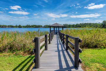Wooden pier overlooking the lake on a summer sunny day in Florida.