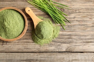 Wheat grass powder and fresh sprouts on wooden table, flat lay. Space for text