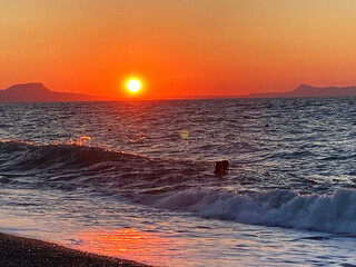 summer sunset on the sea coast in Creta, Greece, at 02 August 2023. Beautiful sunset by the sea in...