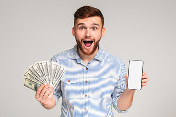 Happy to be reach. Surprised millennial guy with money and cellphone on studio background, blank...