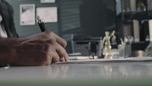 Side closeup of anonymous male lawyer setting his hand and seal on legal document at law firm