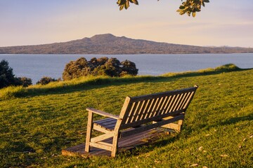 Park Bench on North head at sunset. Rangitoto Island is in the background. Devonport, Auckland, New Zealand.