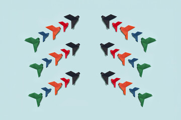 banner three groups of ten paper origami pigeons black, red, orange, blue and green fly up facing...