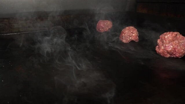 hand puting beef balls to make smash burgers