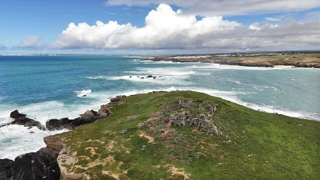 View of the small Pessegueiro island in the Atlantic Ocean. Seagulls are soaring around fortress ruins