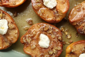 Tasty baked quinces with nuts and cream cheese in dish, top view