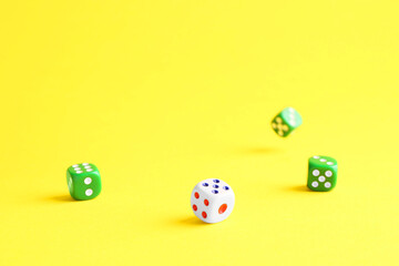 Many color game dices falling on yellow background