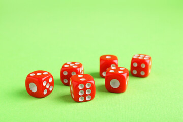Many red game dices on green background, closeup