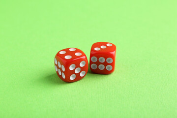 Two red game dices on green background, closeup