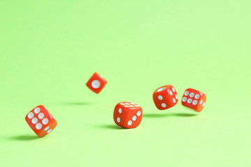 Many red game dices falling on green background