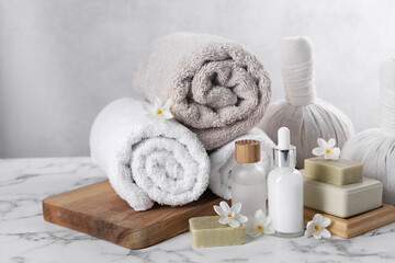 Composition with spa supplies and flowers on white marble table