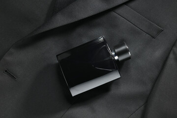 Luxury men's perfume in bottle on black jacket, top view