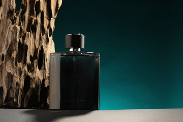 Luxury men`s perfume in bottle on grey table against color background, space for text