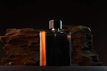 Luxury men`s perfume in bottle on grey table against dark background