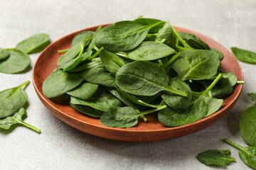 Fresh spinach leaves on light textured table, closeup
