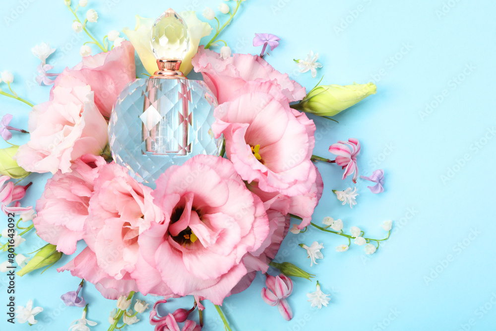 Poster Luxury perfume and floral decor on light blue background, flat lay