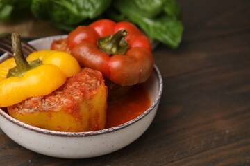 Delicious stuffed bell peppers served on wooden table, closeup. Space for text