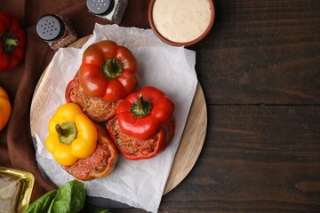 Delicious stuffed bell peppers served on wooden table, flat lay. Space for text